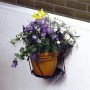Anthrazit Mauer-Topfhalter mit gelbem Topf und bunten Blumen, Ø 18 cm.