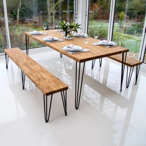 Schwarze 3-Streben Hairpin Tischbeine an einem Holztisch und Bänken in einem hellen Esszimmer. Modernes Design.