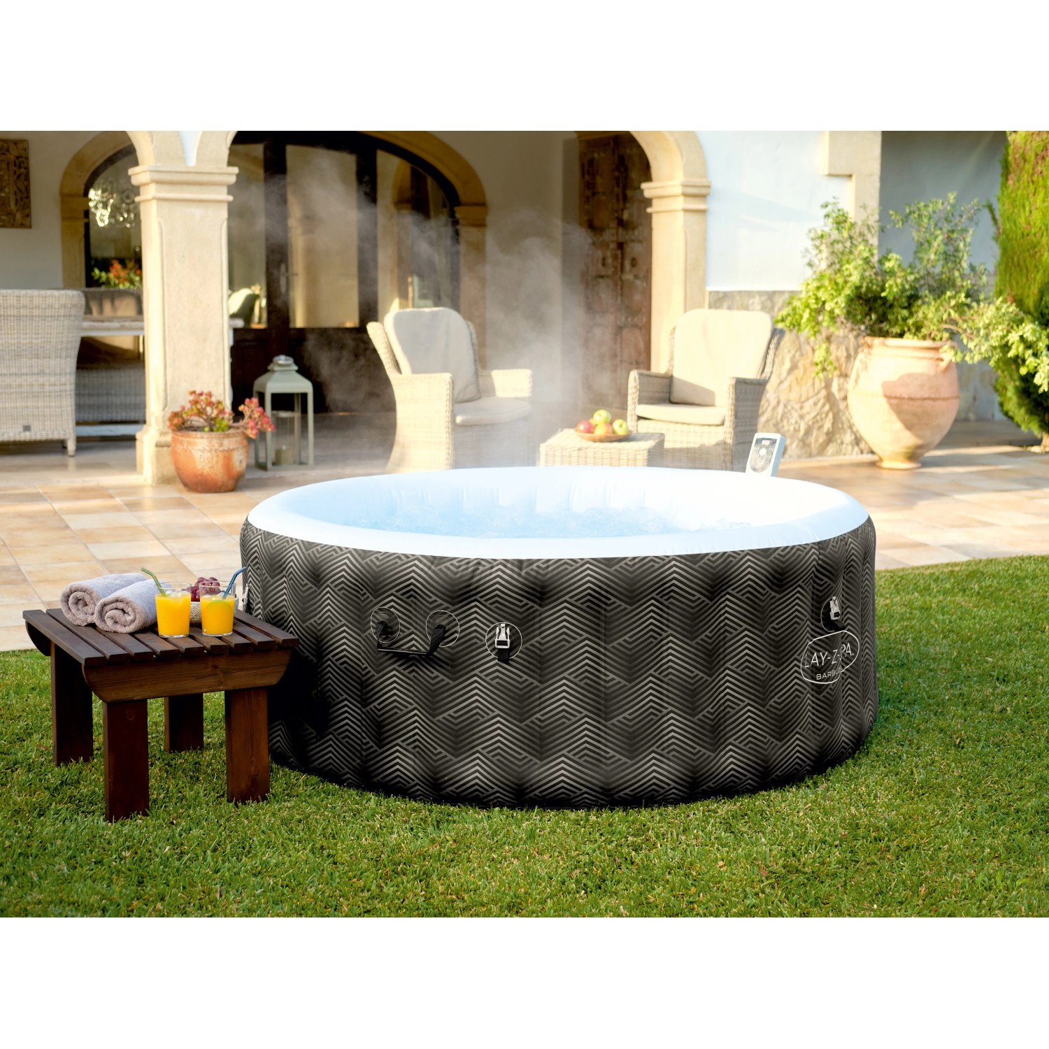 Bestway Lay-Z-Spa Barbuda AirJet aufblasbarer Whirlpool (Ø 180cm) im Garten mit Tisch und Getränken.