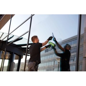 Mann reinigt Fenster mit Unger Fenstereinwascher MicroStrip 35 cm (grün).