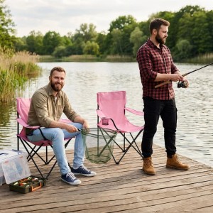 Zwei Angler auf Steg mit rosa Sunula Campingstühlen mit Getränkehalter und Angelausrüstung.