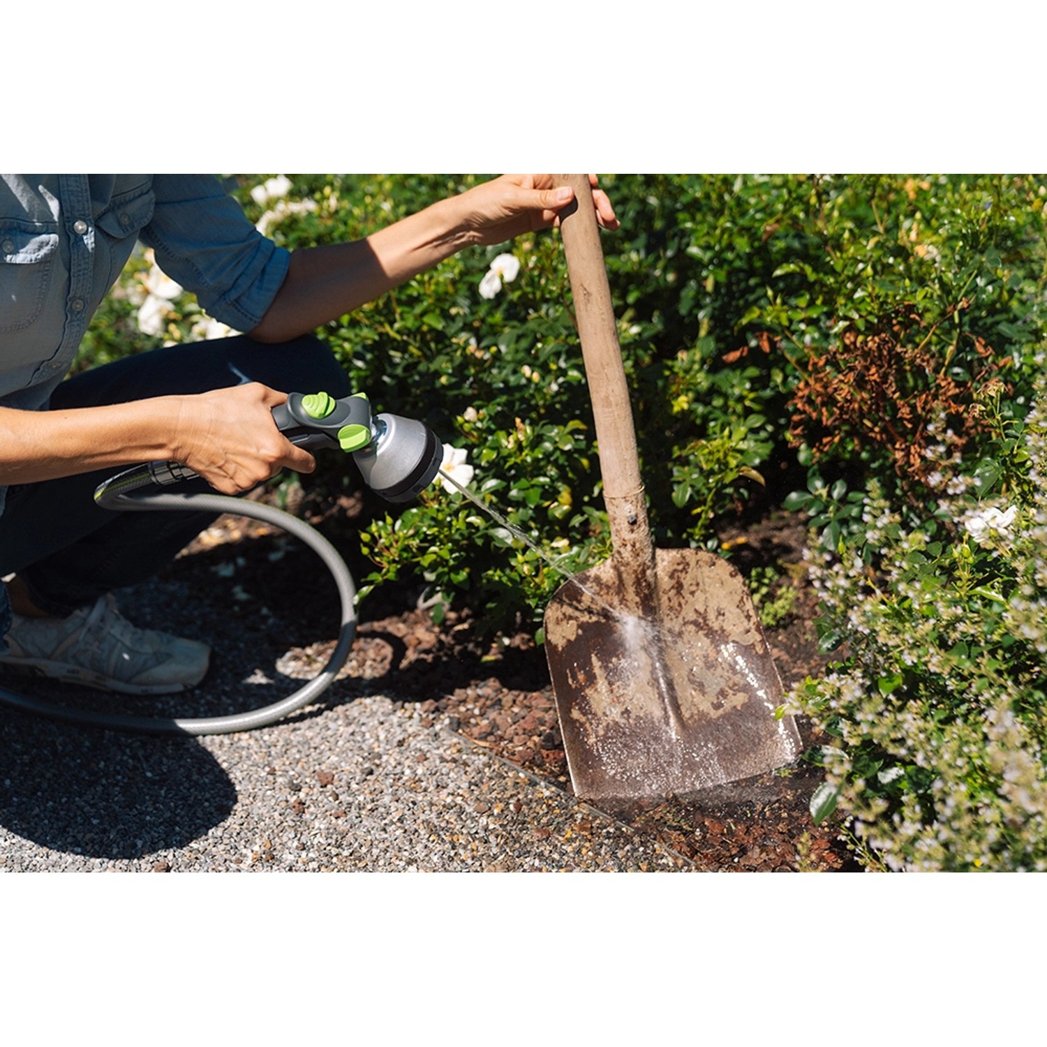 Geka Multibrause Plus 3S Grau im Einsatz beim Bewässern von Pflanzen neben einem Spaten.