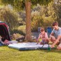 Bosch EasyInflate 18V-500 Akku-Luftpumpe beim Aufpumpen einer Luftmatratze neben einem Zelt.