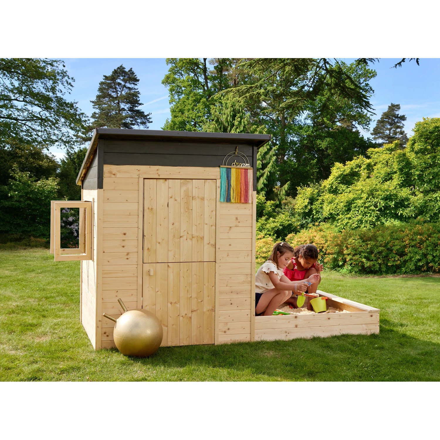Soulet Kinderspielhaus Palm Springs mit Sandkasten und zwei spielenden Kindern im Garten.