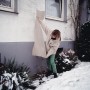 Frau bringt Rosenhaube (3er-Set) zum Schutz vor Schnee an Rose an. Folie und Vlies.