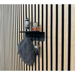 Schwarze FN Acustico Schlüsselablage mit Schlüssel, Hut und Deko an Akustikpaneel Wand.