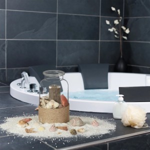 Buntes Muschel Set mit verschiedenen Muscheln und Schnecken, dekorativ arrangiert mit Sand und Kerzen im Bad.