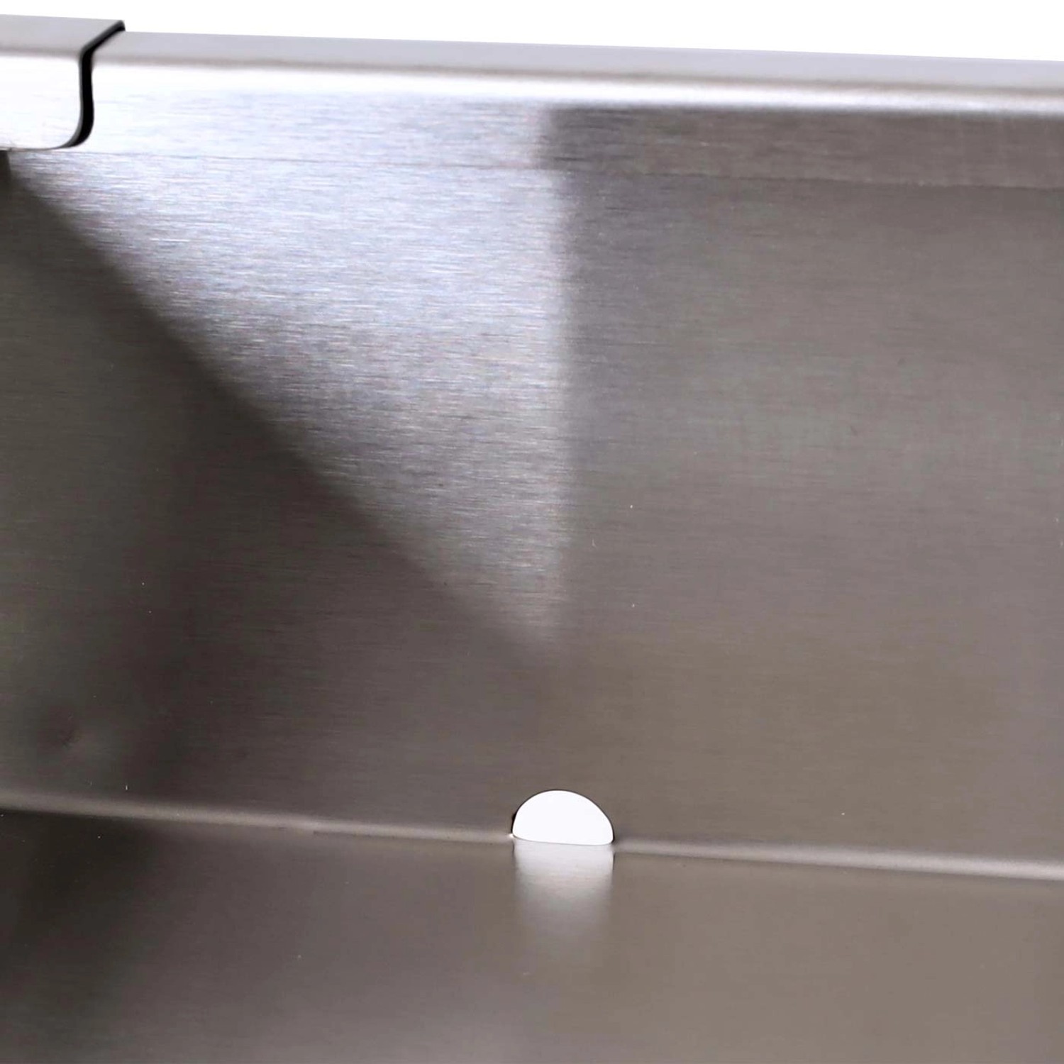 Detailaufnahme: Metall-Innenleben der MCW Mülltonnenverkleidung mit Wasserablaufloch.