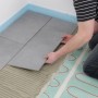 Verlegen der Perobe Elektro Fußbodenheizung 230V (10m²) unter grauen Fliesen. Heizmatte für angenehme Wärme.