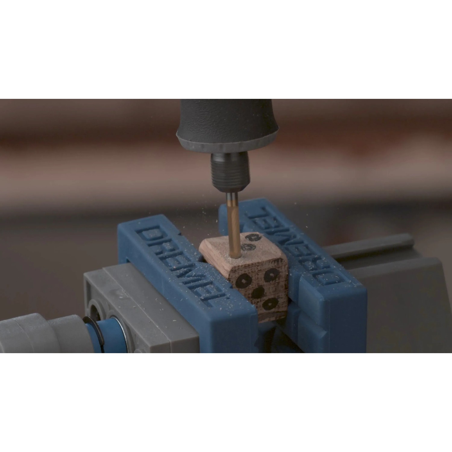 Dremel 9903DM Wolframkarbid-Fräser im Einsatz an einem Holzwürfel in einem Schraubstock.