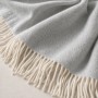 Hellgraue Sofadecke aus Baumwoll-Mix mit weißen Fransen. Weiche Wohndecke 130x170 cm für Sofa und Bett.