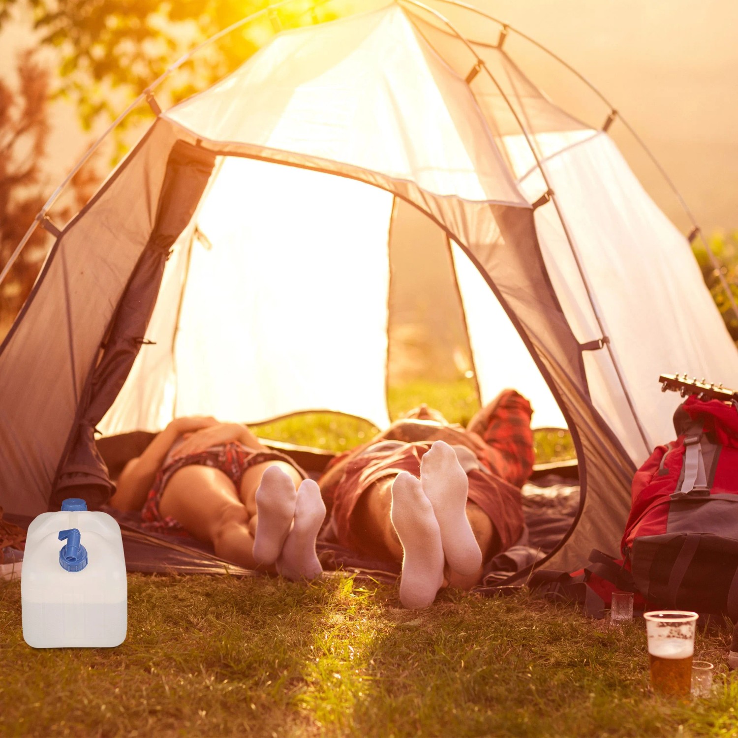 Weiß-blauer 15L Relaxdays Wasserkanister mit Hahn beim Camping vor Zelt.