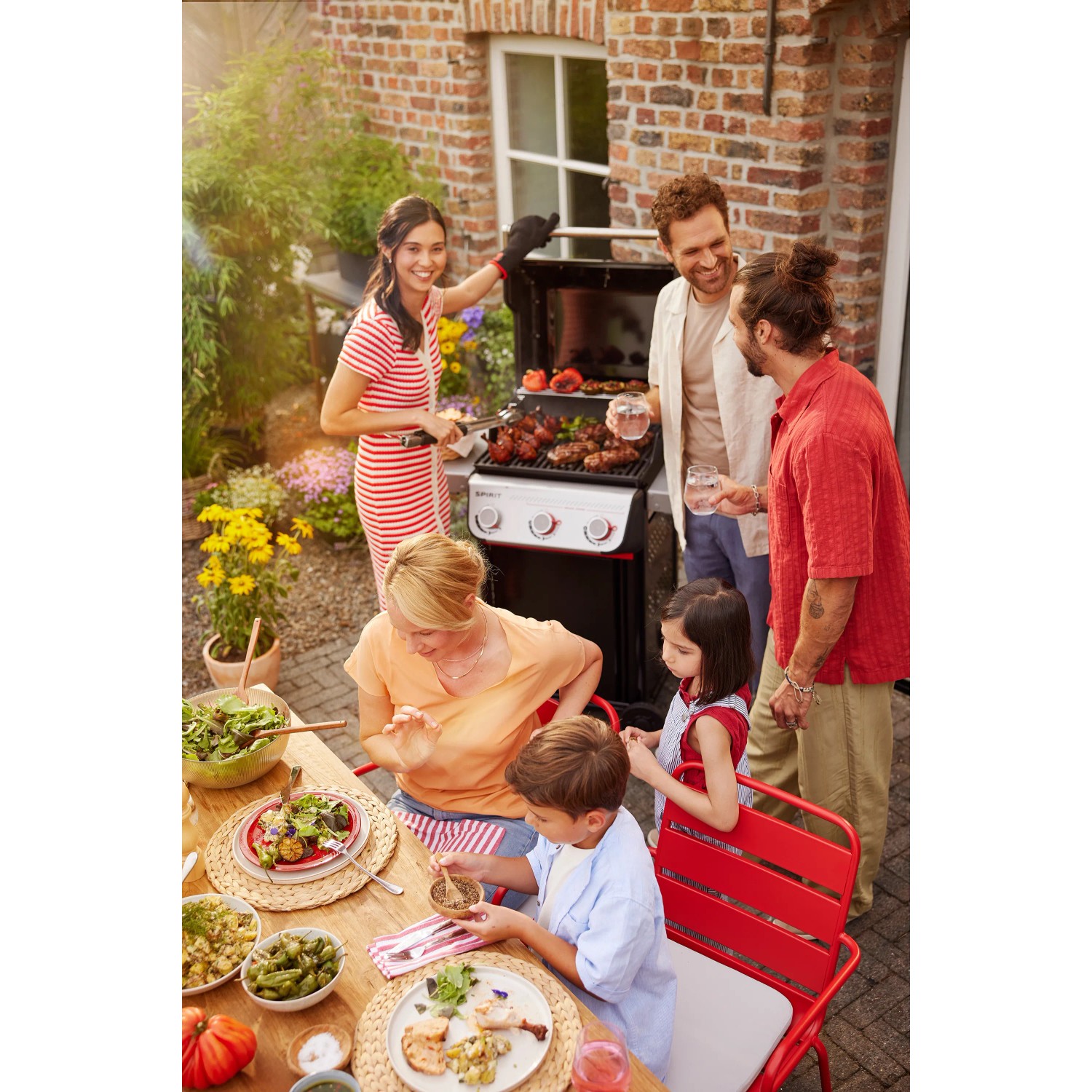 Weber Gasgrill E-310 Spirit (2025) beim Grillen mit Familie und Freunden.