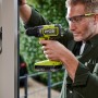 Mann schraubt mit Ryobi Akku-Schlagbohrschrauber RPD18BL2-0, One+ 18V, in Fensterrahmen.