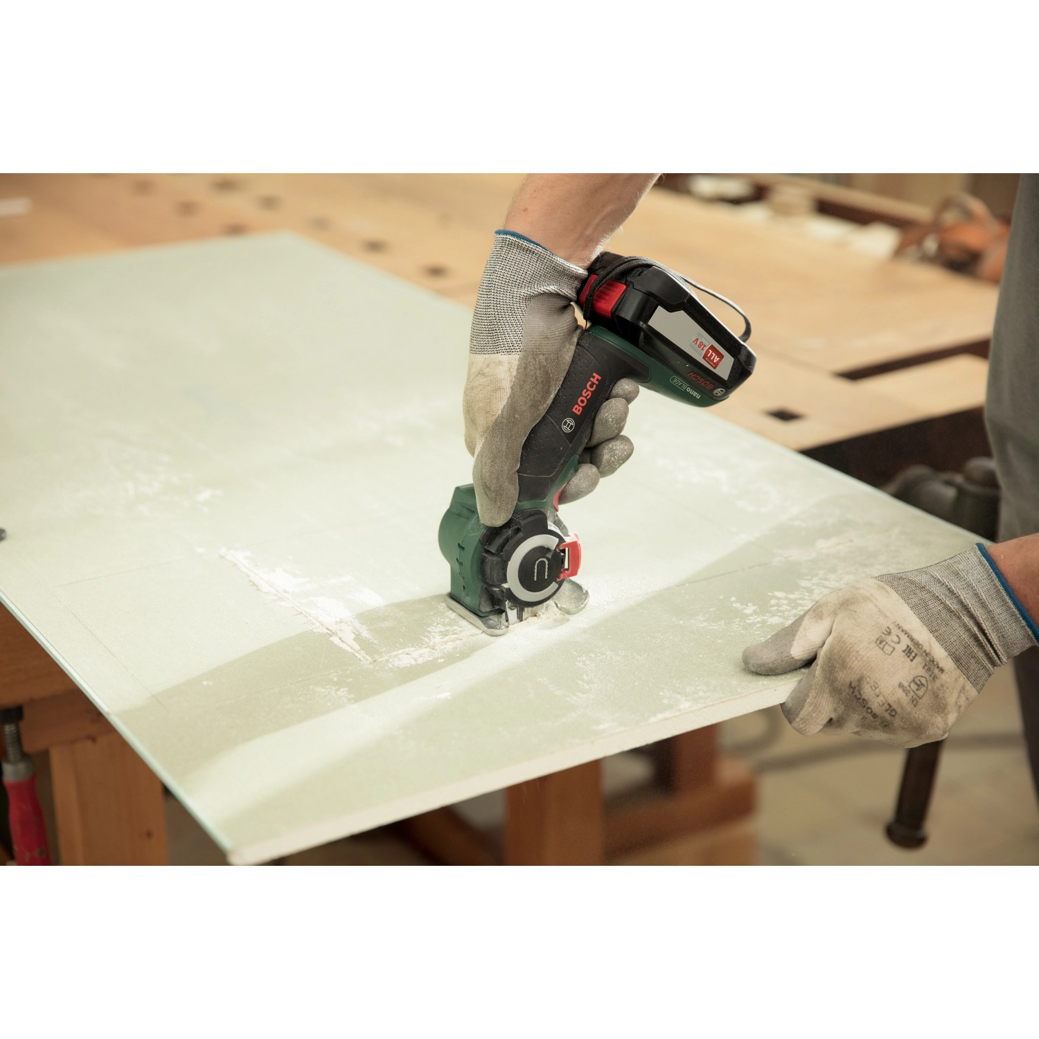 Bosch AdvancedCut 18 Akku-Säge beim Sägen einer Platte, inklusive Akku.