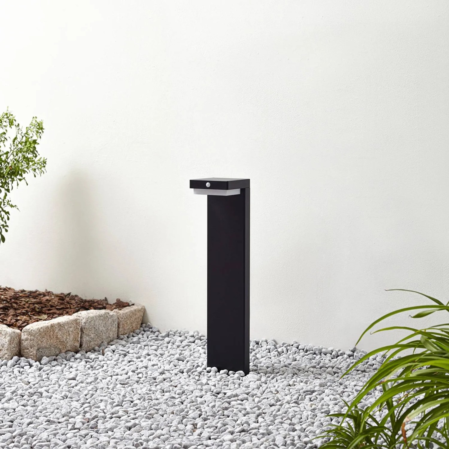 Schwarze Lindby LED Solar-Wegeleuchte Eleazar mit Bewegungsmelder im Garten.