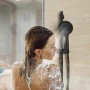 Frau unter der Dusche mit Schütte Stangenbrause-Set Capri Schwarz Matt.
