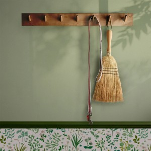 Helle, grüne Joules Vliestapete Uni (10m x 52cm) an Wand mit Besen und Leine.