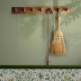Helle, grüne Joules Vliestapete Uni (10m x 52cm) an Wand mit Besen und Leine.