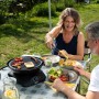 Campingaz 360° Tisch-Grill beim Grillen von Gemüse und Halloumi im Garten.