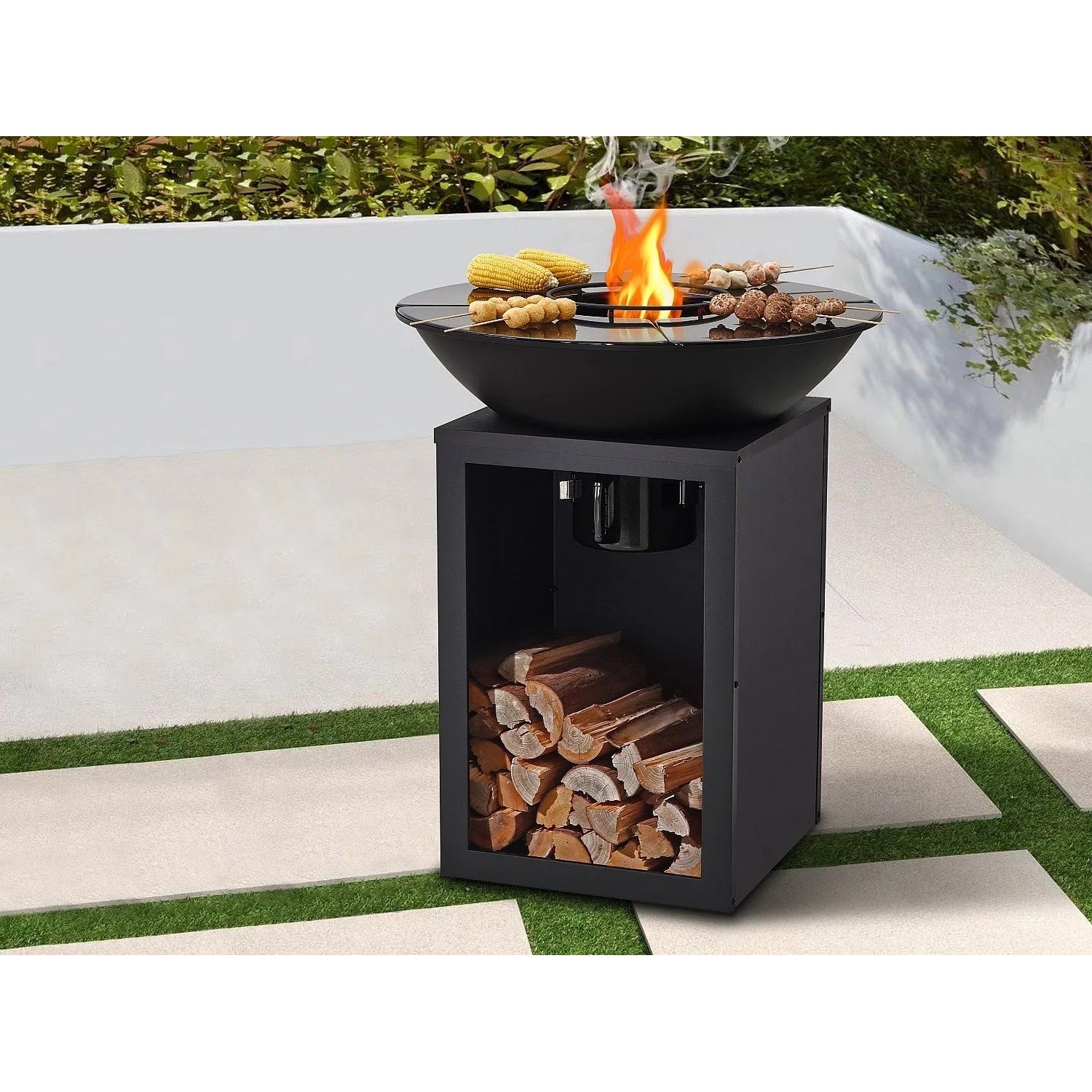 Schwarzer Vente-unique Grill Ignos 80 cm mit Plancha, Feuerschale und Holzfach im Garten. Ideal für BBQ.