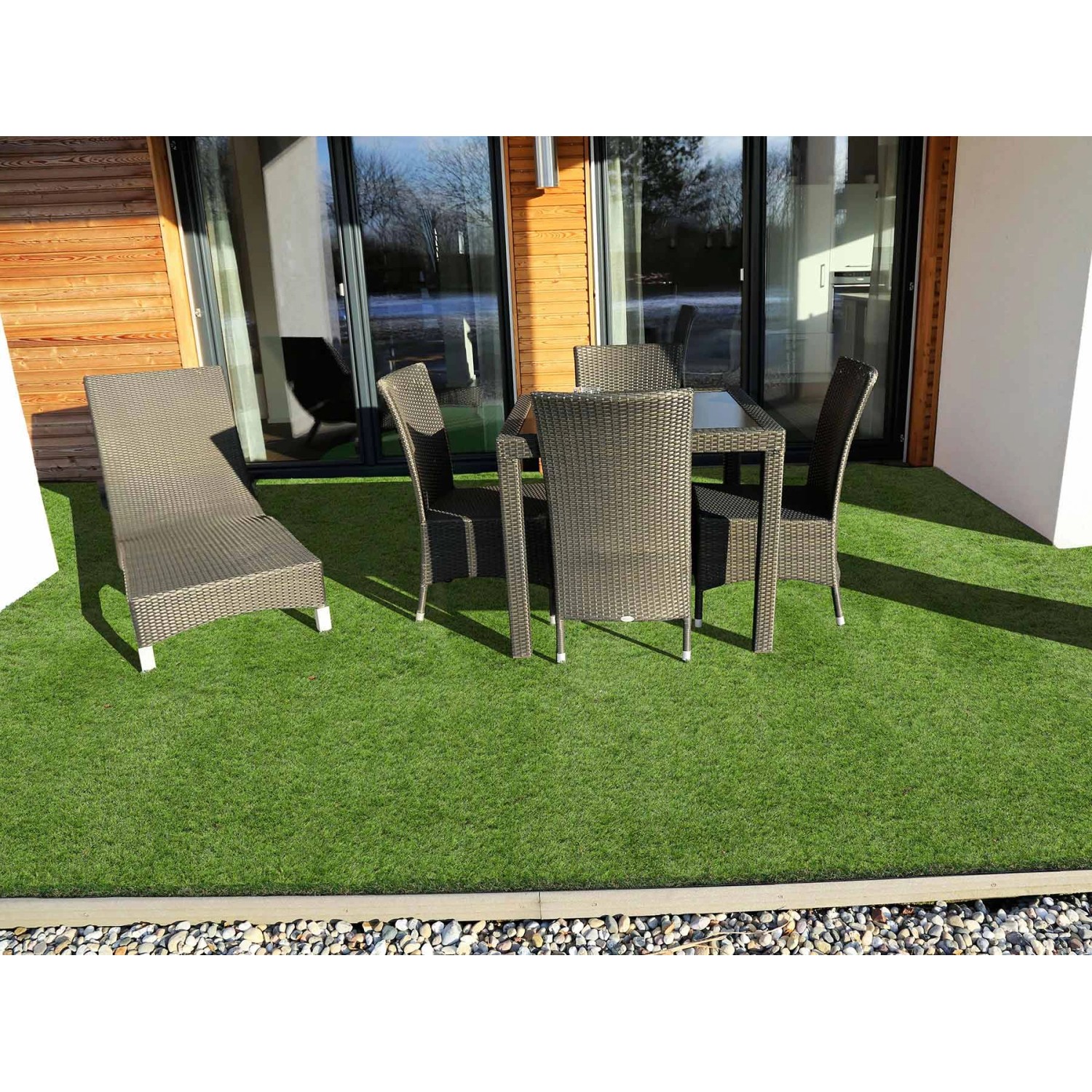 Verlegter grüner Primaflor Kunstrasen Woodland mit Gartenmöbeln auf Terrasse.