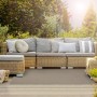 Wetterfester, grauer KARAT Outdoor Teppich Pavia (90x150 cm) auf einer Terrasse mit Gartenmöbeln.