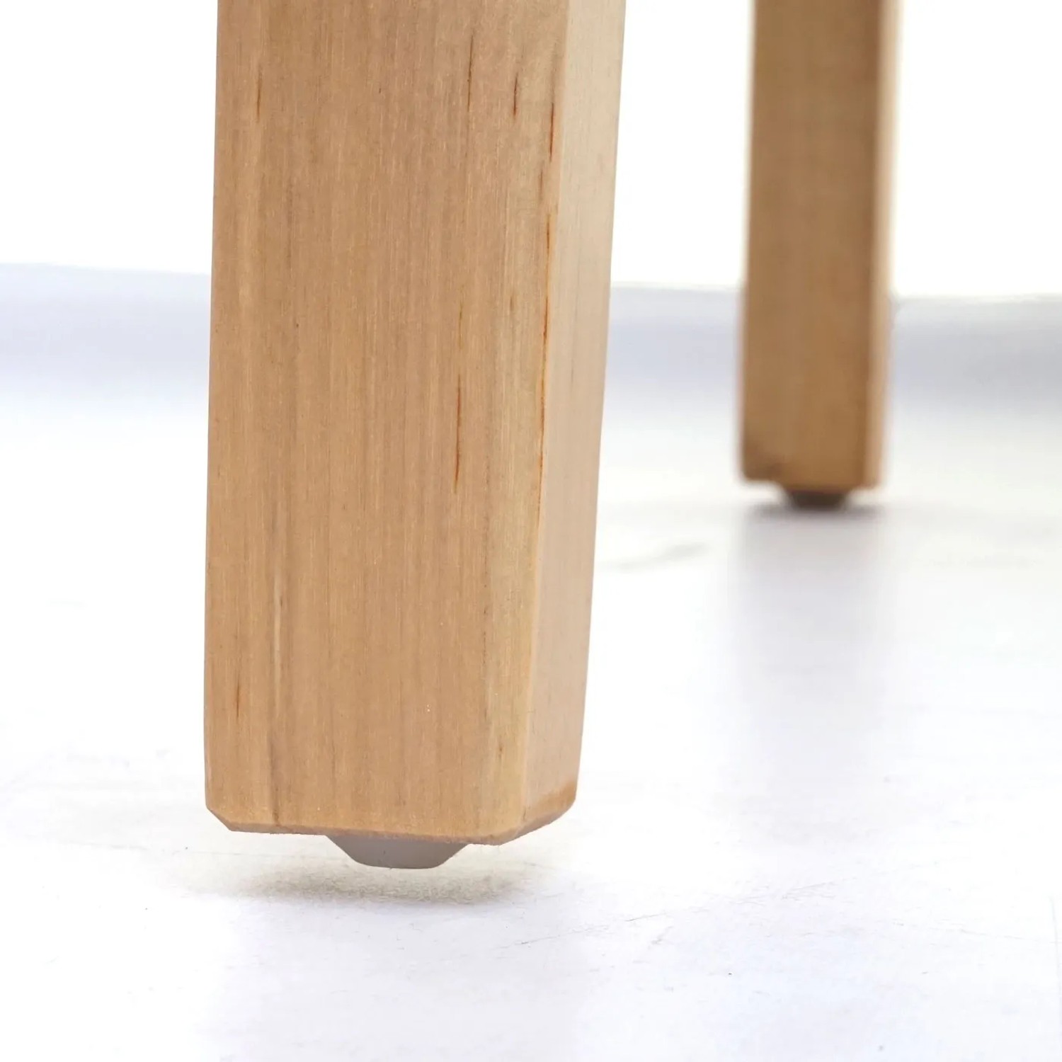 Detailaufnahme: Helle Holzbeine des MCW Esszimmerstuhls Littau mit Bodenschoner.