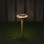 Graue Solarleuchte Johannesburg mit Erdspieß im Garten, leuchtet warmweiß.