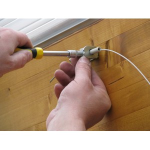 Montage des Floracord Seilspanntechnik Bausatzes mit Schraubendreher an einer Holzwand.