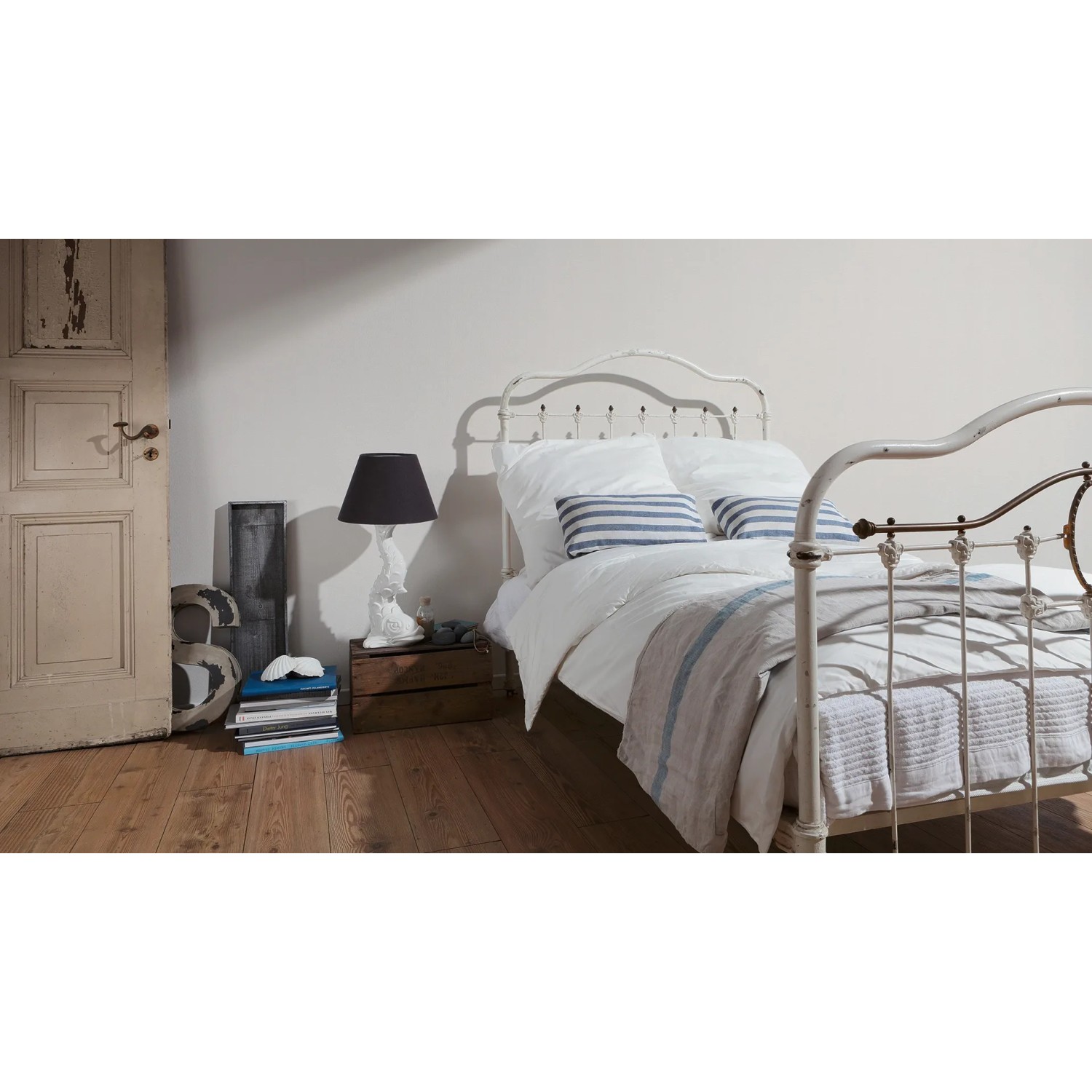 Schlafzimmer mit weißer Vliestapete Elegance 2 Uni Weiß FSC® an der Wand.