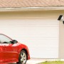 Technaxx Outdoor-Kamera TX-244 Solar am Haus mit rotem Auto davor.