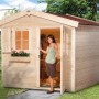 OBI Holz-Gartenhaus Bozen, unbehandelt, mit Fenster und blühendem Blumenkasten. Frau betritt das Gartenhaus.
