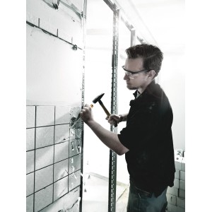 Handwerker stemmt Fliesen mit Wera Schraubendreher und Hammer. Schraubendreher-Set für Stemmarbeiten.