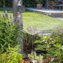 Gardena smart Water Control Bewässerungscomputer im Garten mit laufender Bewässerung.
