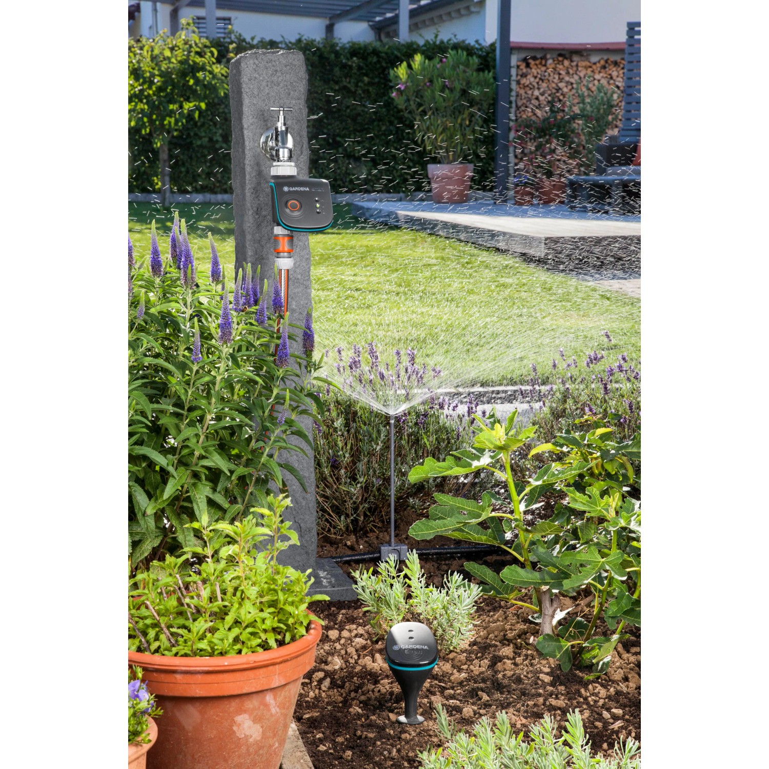 Gardena smart Water Control Bewässerungscomputer im Garten mit laufender Bewässerung.