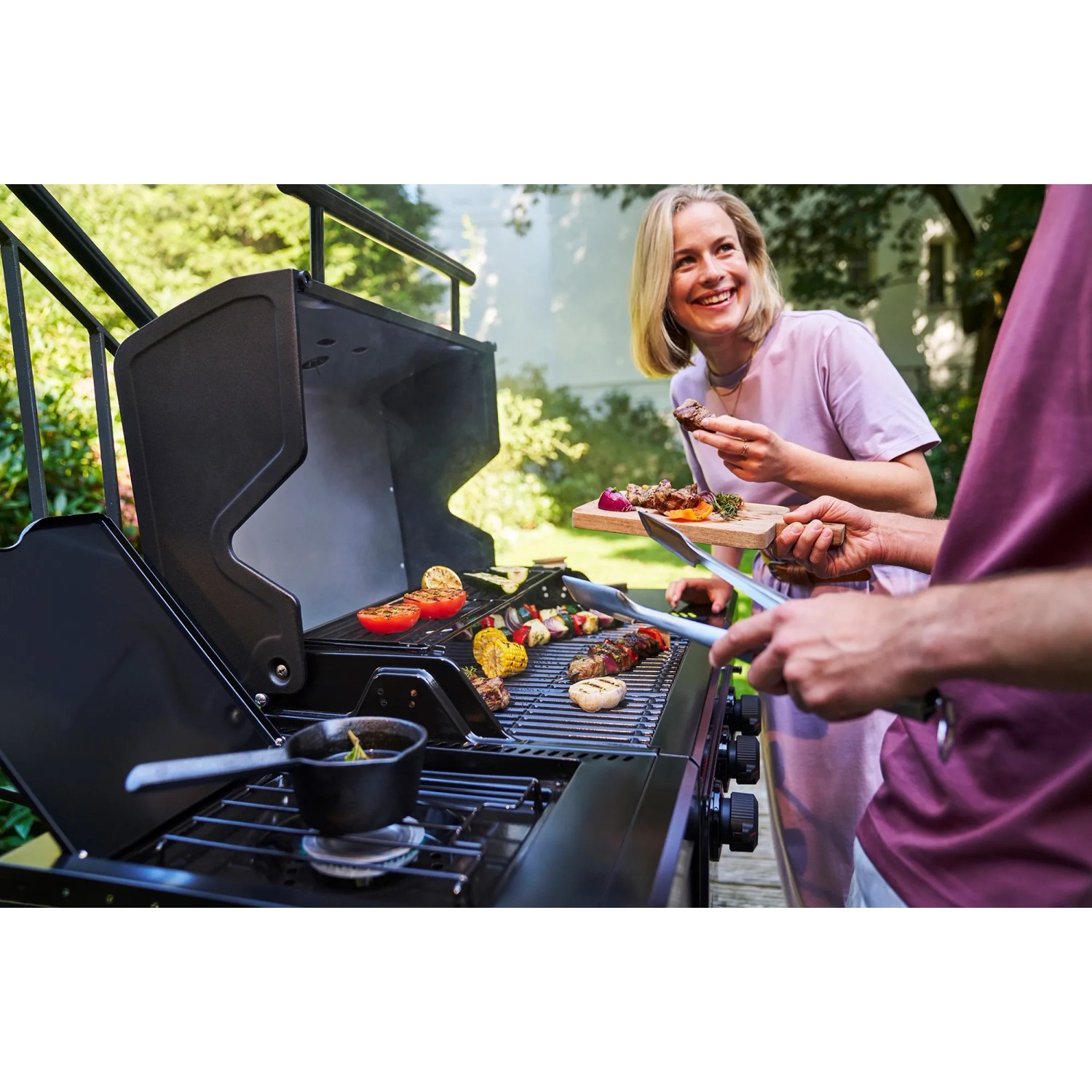 Char-Broil Gasgrill Essential 3 G mit Seitenbrenner beim Grillen von Gemüse und Fleisch.
