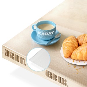 Transparente KARAT Tischfolie 40x200cm mit abgeschrägter Kante auf Tisch mit Kaffee und Croissants.