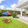 Bunter Axi Nick Picknicktisch Regenbogen mit Sonnenschirm im Garten.
