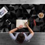 Schwarze Schreibtischunterlage mit abstraktem 3D-Muster auf weißem Schreibtisch, Person zeichnet. Ideal für Büro & Homeoffice.