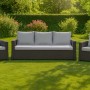 Graue Gartenkissen für Polyrattan Gartenmöbel: Komfortables Set für 3-Sitzer Sofa und 2 Sessel auf Rasen im Garten.