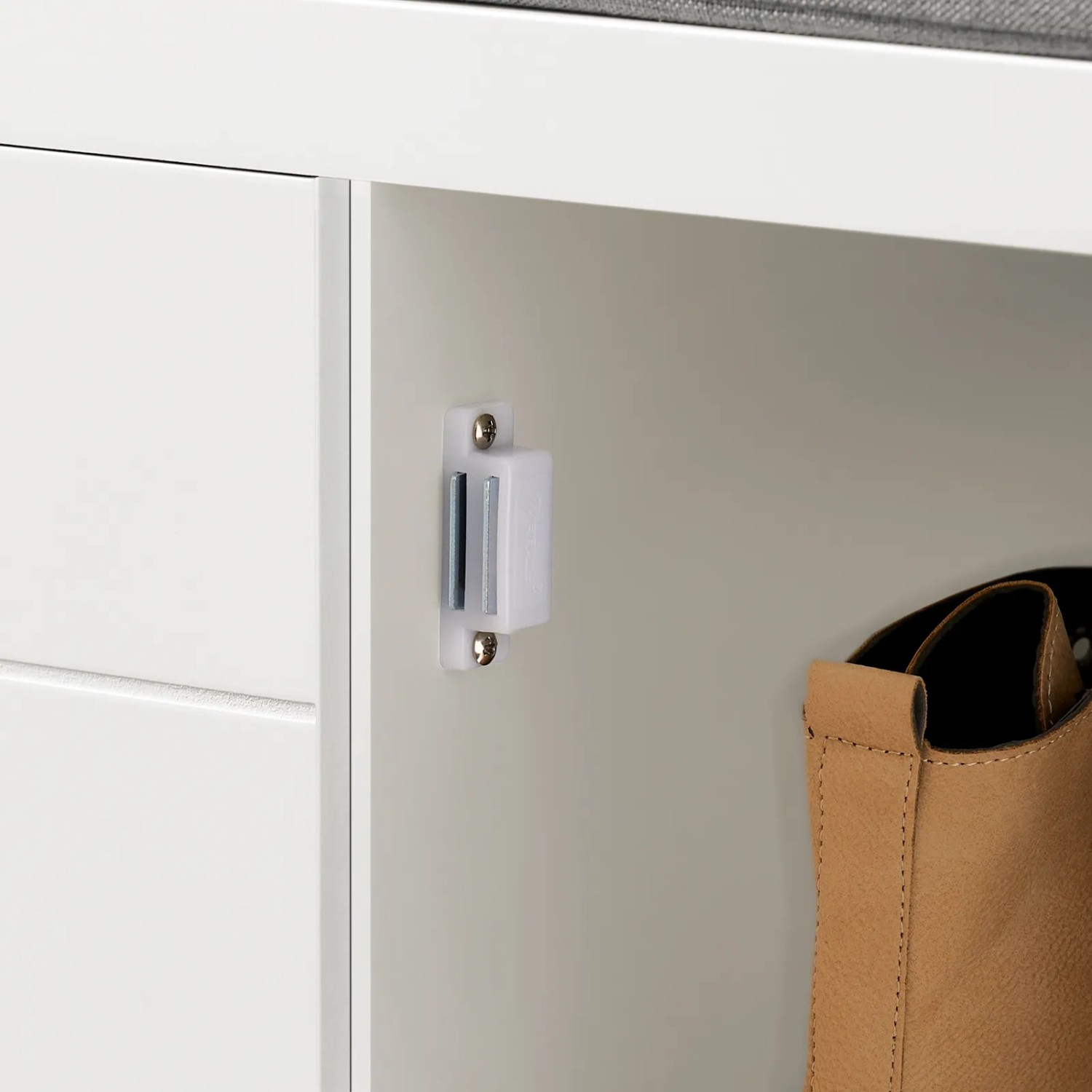 Detailaufnahme: Weiße Schuhbank mit grauem Sitzkissen und Stauraum für Schuhe.