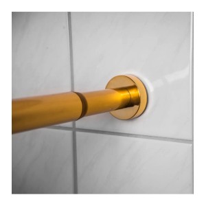 Sanilo Duschvorhangstange Gold (120-220cm) an weißer Wand.