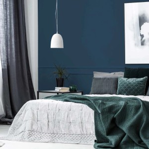 Modernes Schlafzimmer mit dunkelblauer Wandfarbe. Tadessi Wall Select Dispersion für stilvolle bunte Wände.