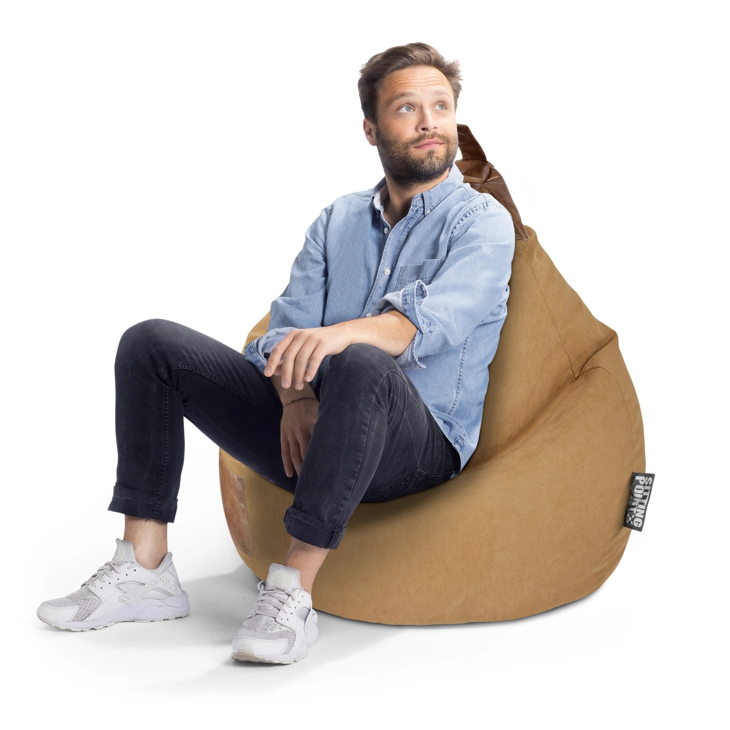 Mann sitzt entspannt im sandfarbenen Sitting Point Sitzsack Jamie 220 l.