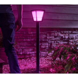 Philips Hue Econic LED-Wegeleuchte in Schwarz mit pinkfarbenem Licht im Garten.