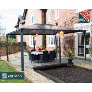 Canopia Gartenpavillon Martinique 3.6 x 5 Anthrazit mit Tisch und Stühlen im Garten.