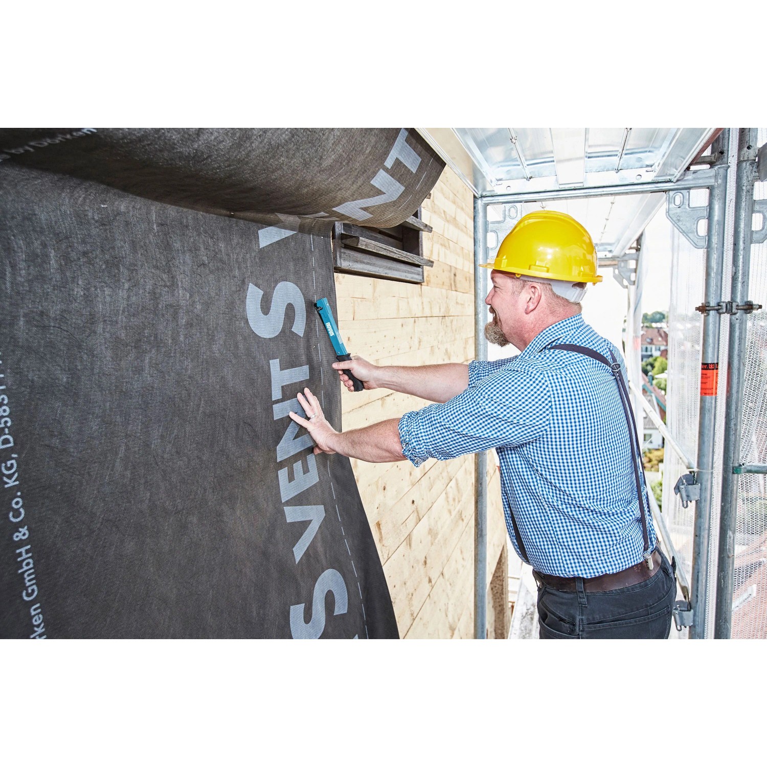 Handwerker befestigt Folie mit Novus Hammertacker J-022. Premium Tacker für Klammern Typ H.