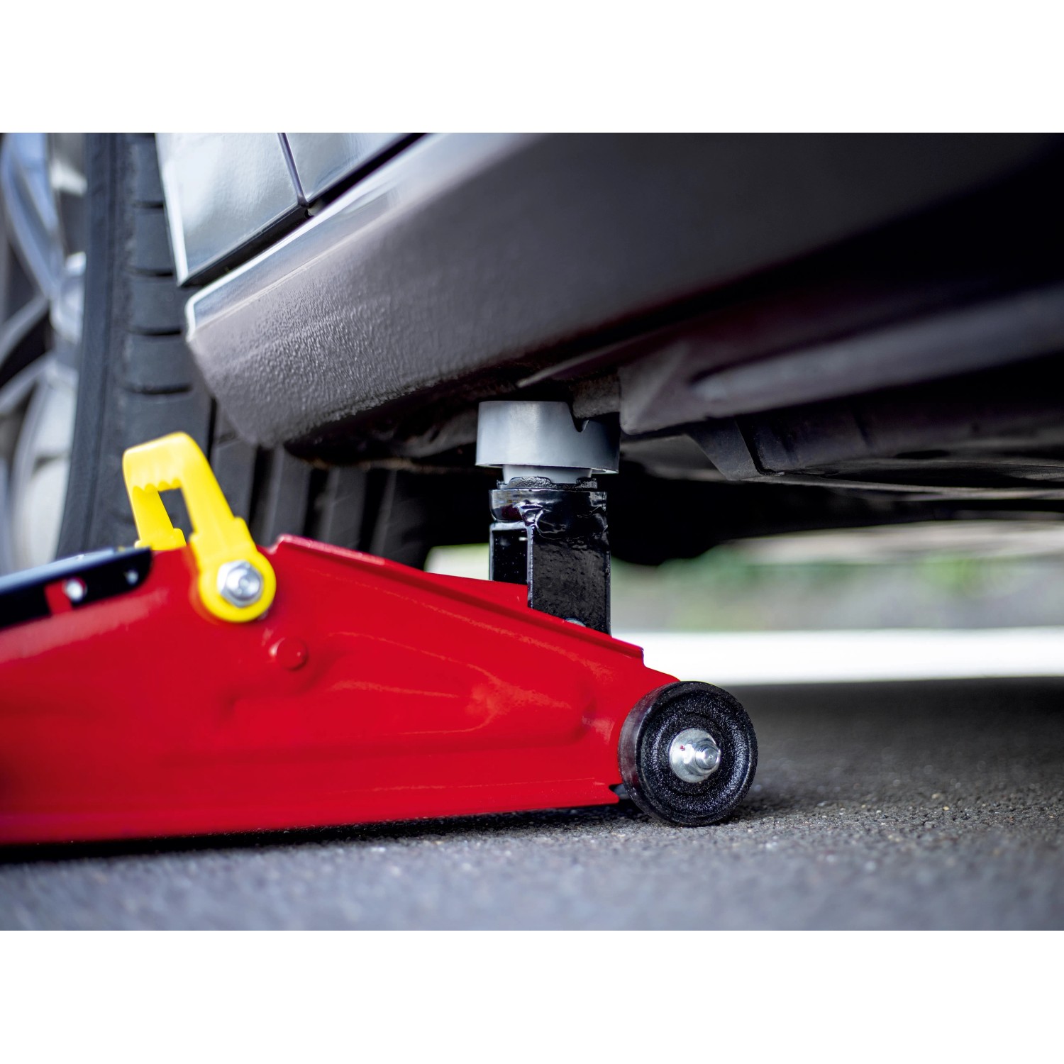 Gummiauflage auf Wagenheber unter Auto, Ø 65mm, für Wartung und Reparatur.
