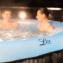 MSpa Lite Glow AirJet aufblasbarer Whirlpool mit LED-Beleuchtung und zwei Personen im Wasser.